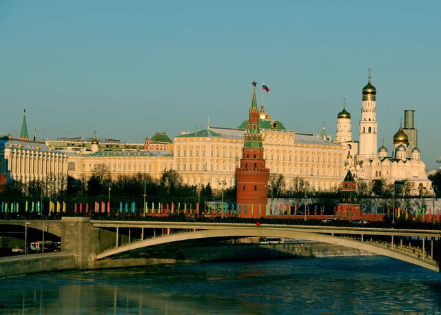 Scenic view of Moscow's iconic Kremlin and bridge under clear daylight.